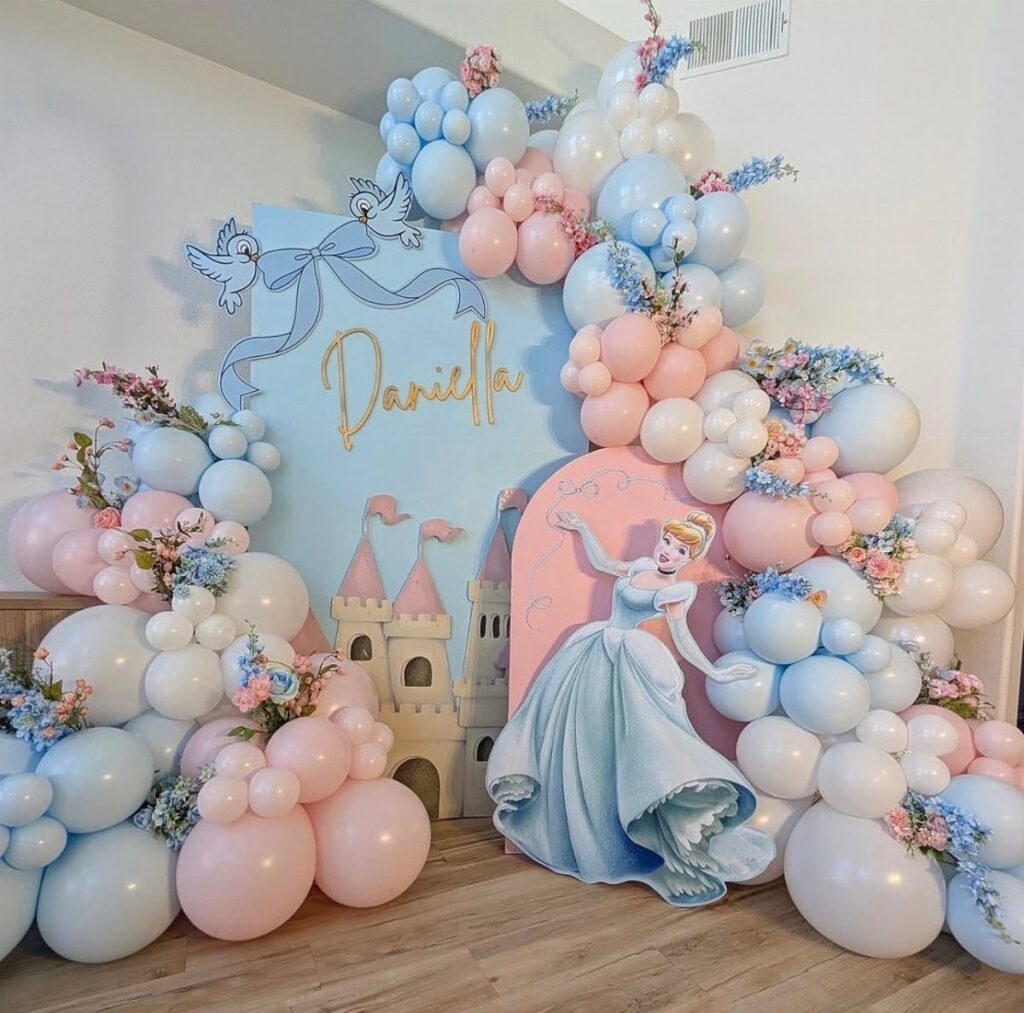 Cinderella party backdrop with blue and pink balloons and a toy castle