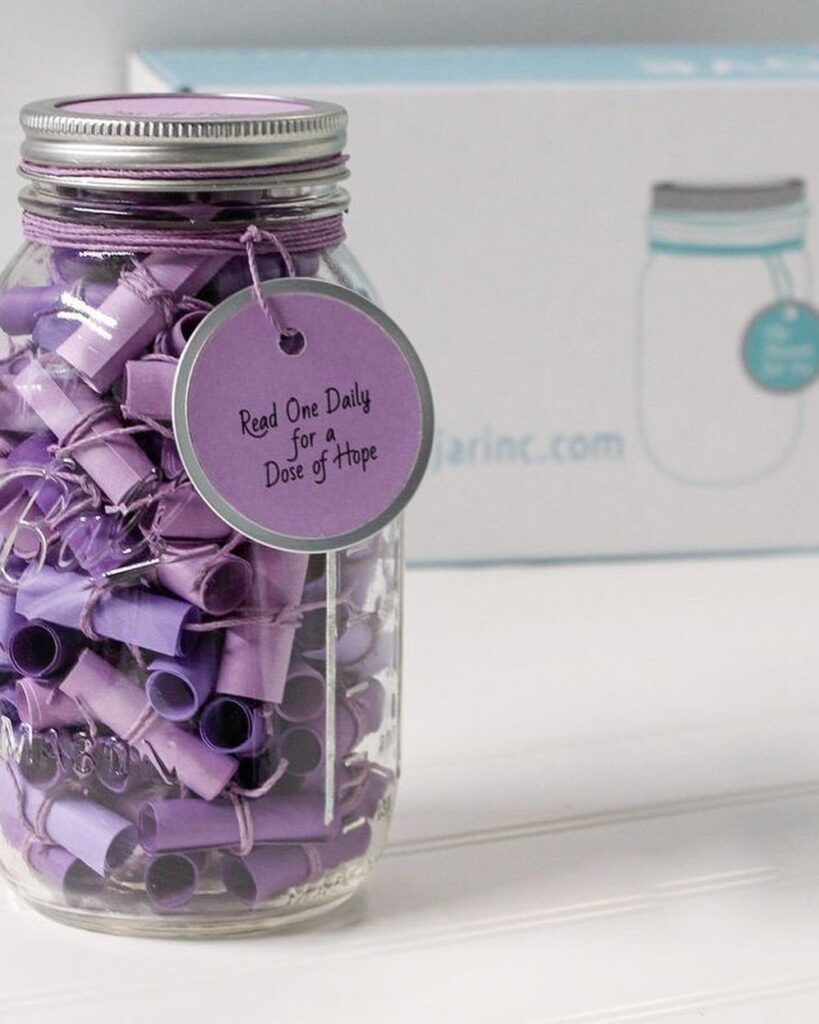 Glass mason jar filled with rolled purple notes and a hope tag.