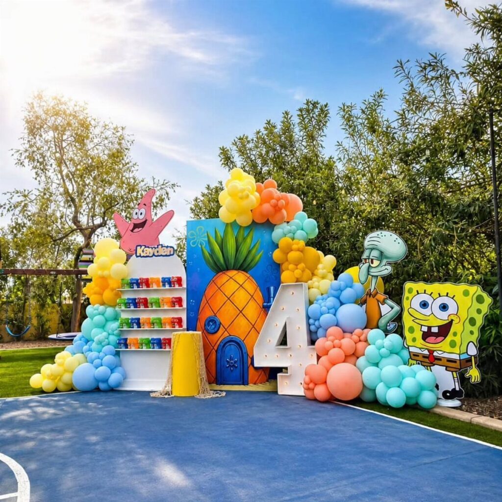 SpongeBob SquarePants themed birthday party decoration with balloons and character cutouts outdoors