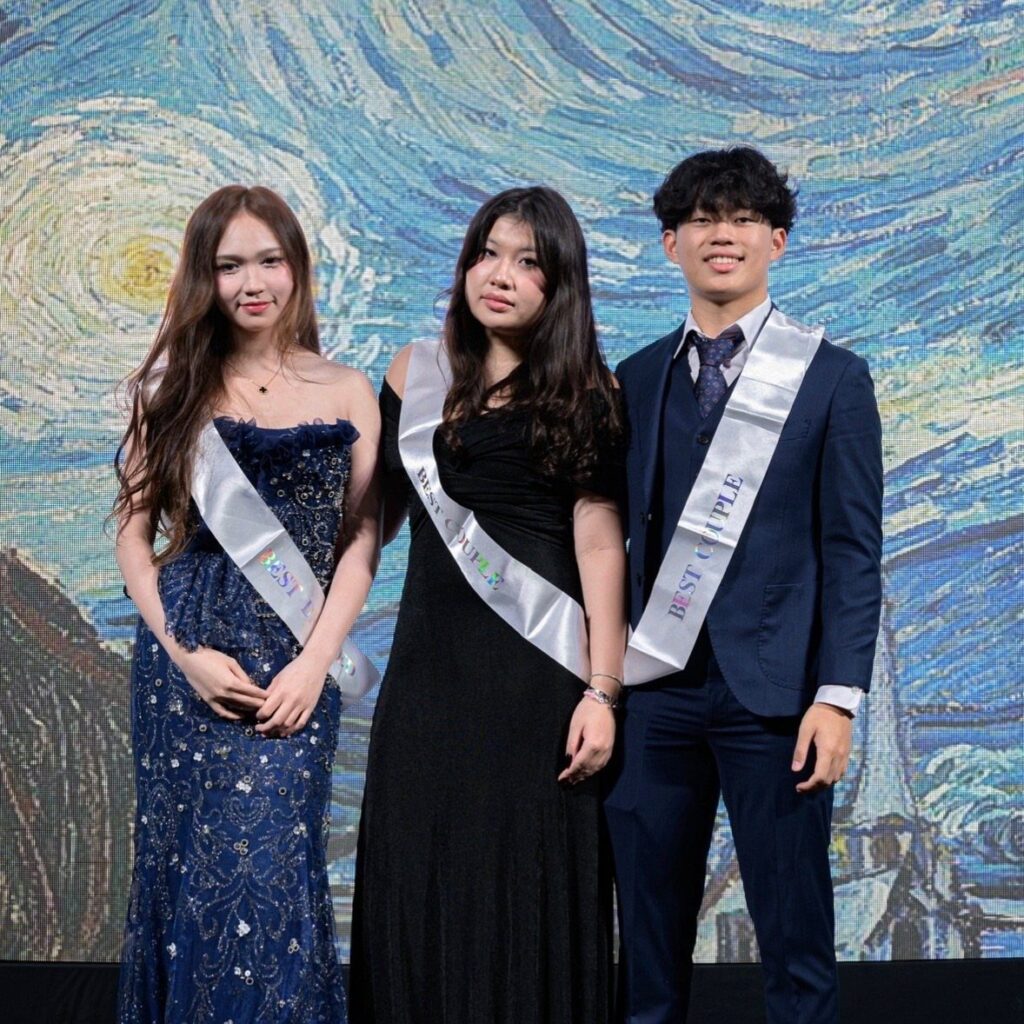 Three students in formal wear posing before a Starry Night themed backdrop.