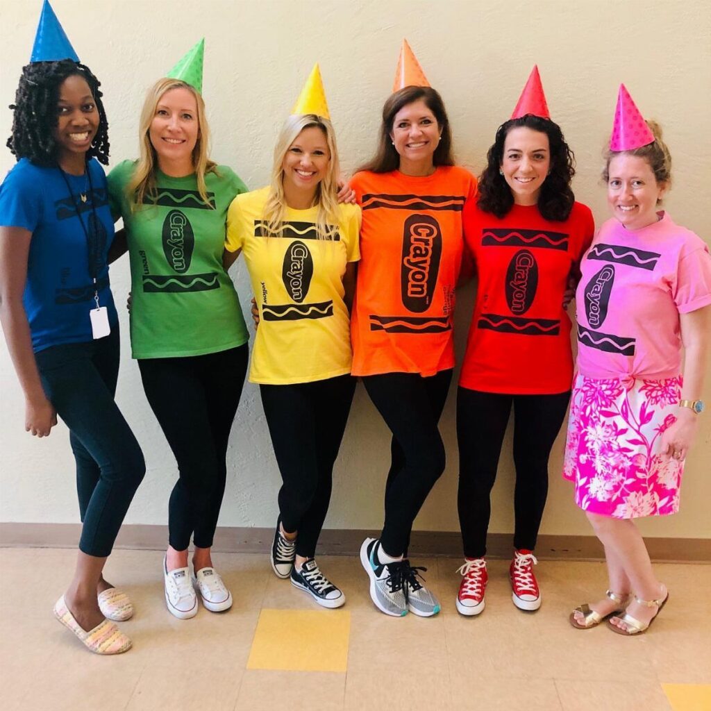 Six women wearing colorful t-shirts and cone hats as a group crayon costume.